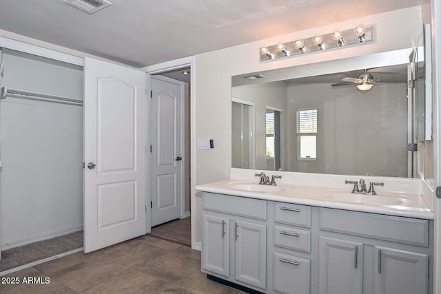 bathroom featuring ceiling fan, double vanity, visible vents, and a sink