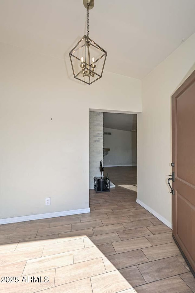 interior space featuring a chandelier, baseboards, and wood finish floors