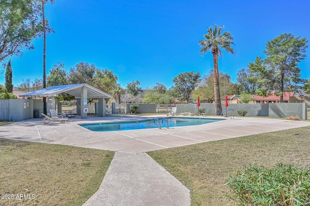 pool with a patio area, fence, and a lawn