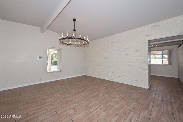 empty room with baseboards, wood finished floors, a chandelier, and brick wall