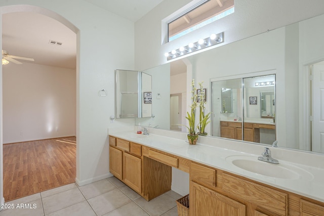 bathroom featuring vanity, a towering ceiling, tile patterned floors, and ceiling fan