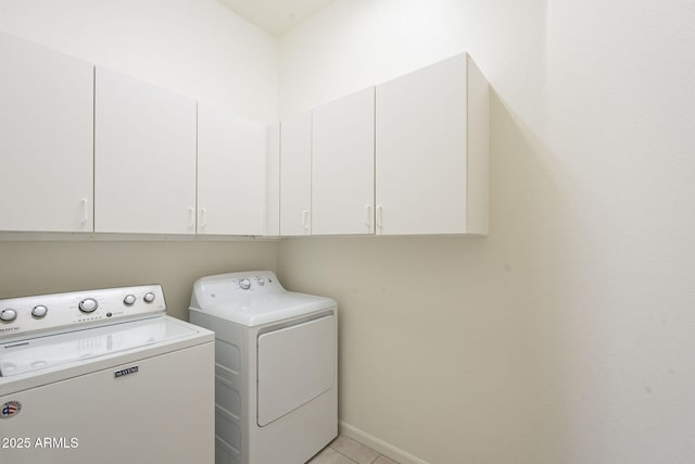 laundry room featuring cabinets, washer and dryer, and light tile patterned floors