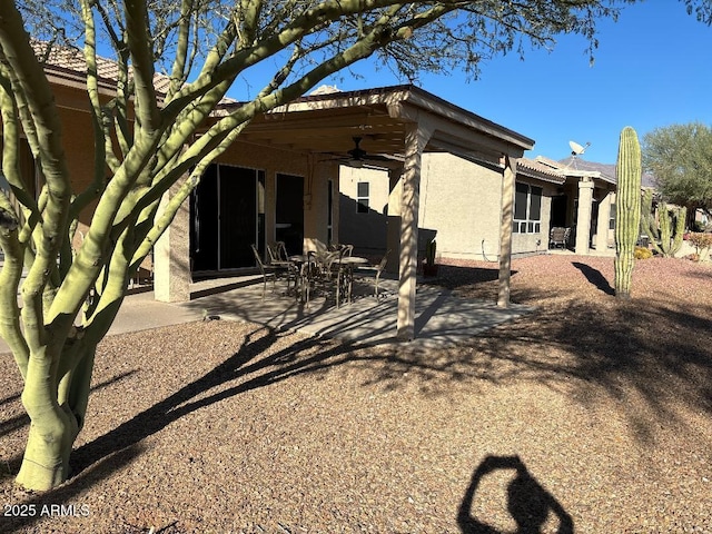 back of property featuring ceiling fan and a patio area