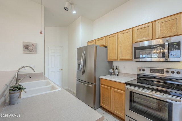 kitchen with appliances with stainless steel finishes, sink, light brown cabinets, and light tile patterned floors