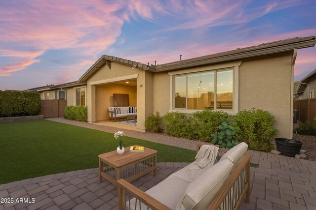 back of house featuring a yard, a patio area, fence, and stucco siding