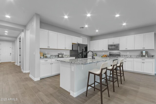 unfurnished living room with recessed lighting, visible vents, and light wood-type flooring