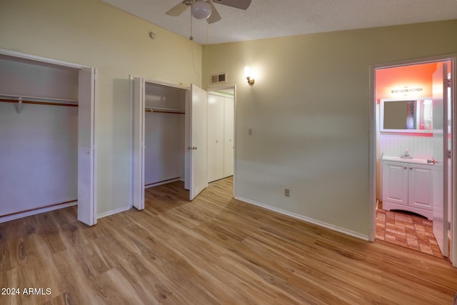 322 N Flynn Jans Ct, Pearce, AZ 85625 - unfurnished bedroom with multiple closets, lofted ceiling, baseboards, light wood-style flooring, and ceiling fan
