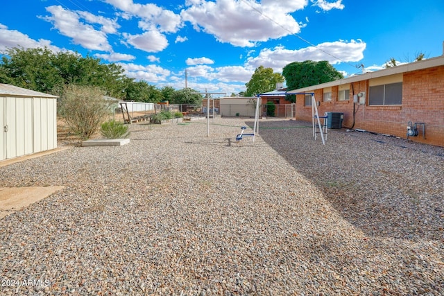 322 N Flynn Jans Ct, Pearce, AZ 85625 - view of yard featuring central AC unit, a playground, fence, a storage shed, and an outdoor structure