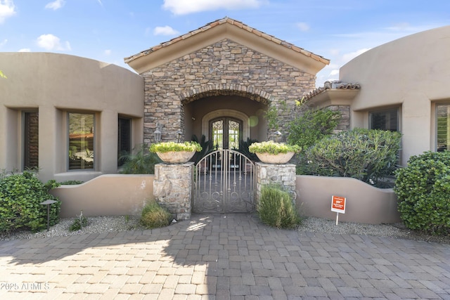 13249 E Summit Dr, Scottsdale, AZ 85259 - view of exterior entry featuring french doors, a gate, stucco siding, and stone siding