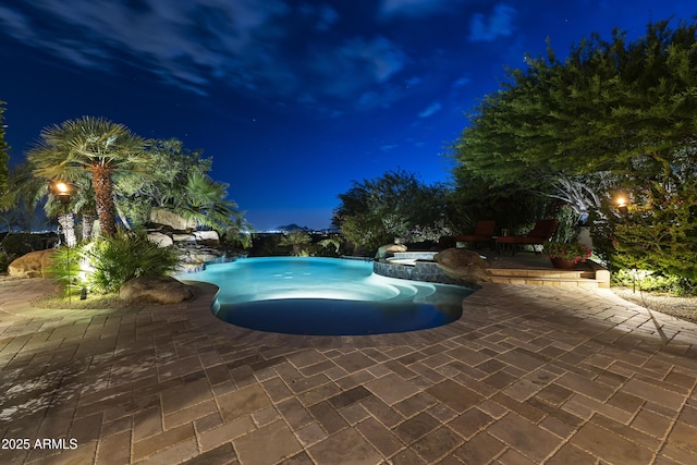 13249 E Summit Dr, Scottsdale, AZ 85259 - pool at night with a patio and a pool with connected hot tub