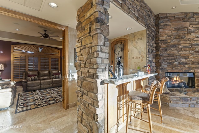 13249 E Summit Dr, Scottsdale, AZ 85259 - bar area featuring a ceiling fan, a stone fireplace, recessed lighting, and stone finish flooring