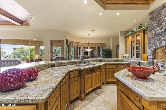 13249 E Summit Dr, Scottsdale, AZ 85259 - kitchen featuring brown cabinets, recessed lighting, crown molding, light stone countertops, and glass insert cabinets