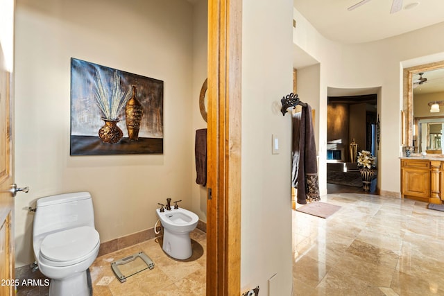 13249 E Summit Dr, Scottsdale, AZ 85259 - bathroom with ceiling fan, a bidet, toilet, vanity, and a fireplace