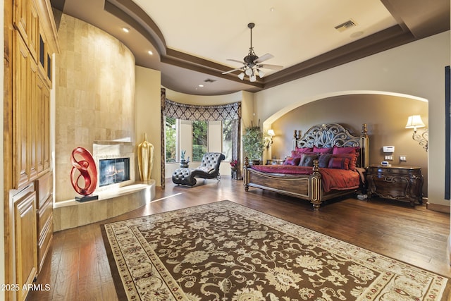 13249 E Summit Dr, Scottsdale, AZ 85259 - bedroom featuring wood-type flooring, a tiled fireplace, baseboards, recessed lighting, and ceiling fan