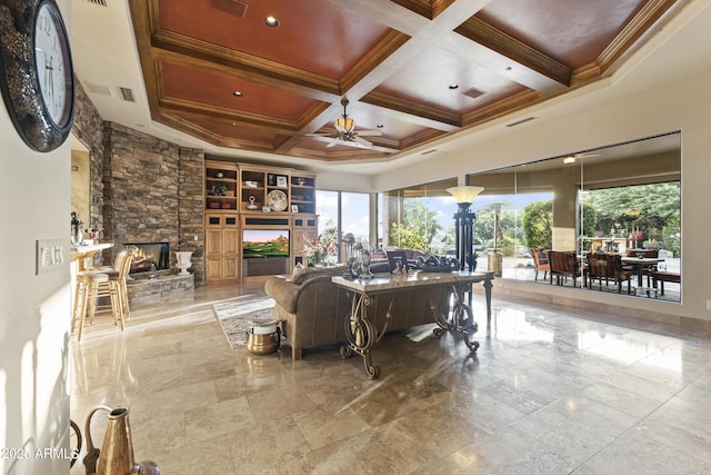 13249 E Summit Dr, Scottsdale, AZ 85259 - living room with a ceiling fan, a stone fireplace, coffered ceiling, beam ceiling, and crown molding