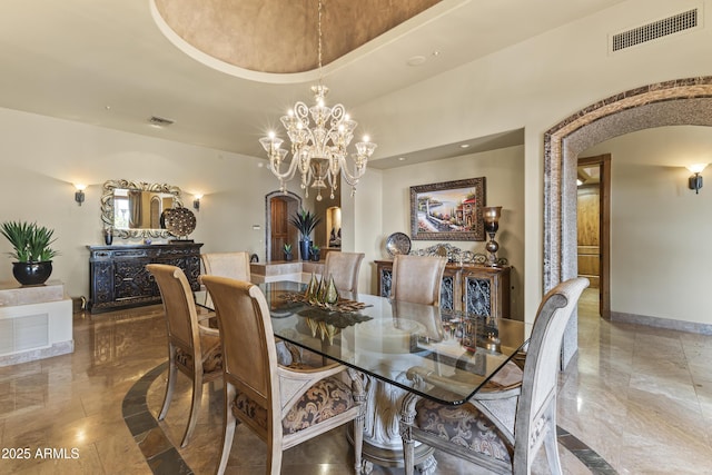 13249 E Summit Dr, Scottsdale, AZ 85259 - dining room with arched walkways, baseboards, and a chandelier