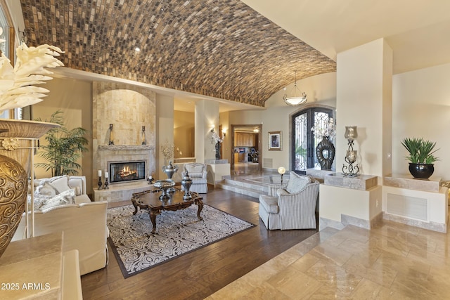 13249 E Summit Dr, Scottsdale, AZ 85259 - living area with a fireplace, lofted ceiling, brick ceiling, french doors, and baseboards