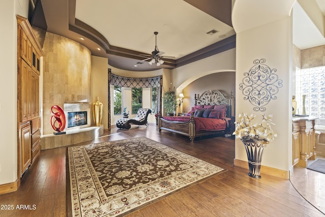 13249 E Summit Dr, Scottsdale, AZ 85259 - bedroom with a tiled fireplace, multiple windows, baseboards, and dark wood finished floors