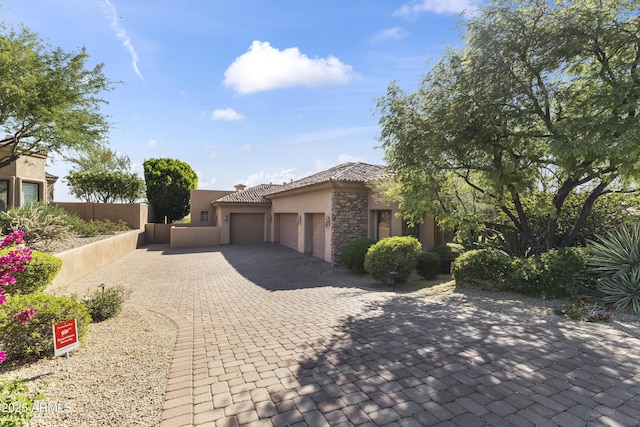 13249 E Summit Dr, Scottsdale, AZ 85259 - view of front of house with a garage, stucco siding, stone siding, decorative driveway, and a tiled roof