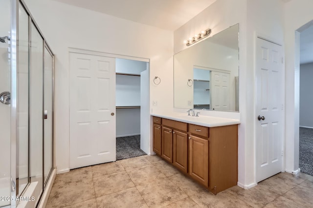 8766 W Hayward Ave, Glendale, AZ 85305 - full bath with a shower stall, vanity, a spacious closet, and tile patterned flooring