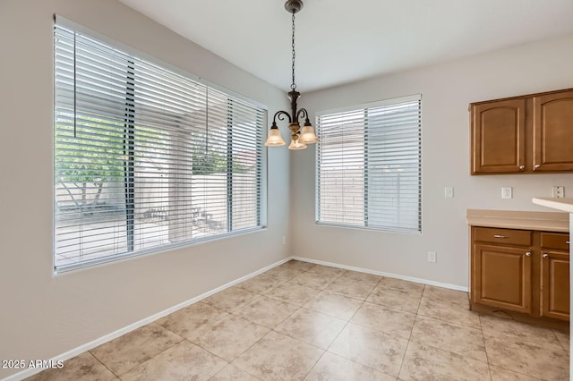 8766 W Hayward Ave, Glendale, AZ 85305 - unfurnished dining area featuring a chandelier, light tile patterned floors, and baseboards