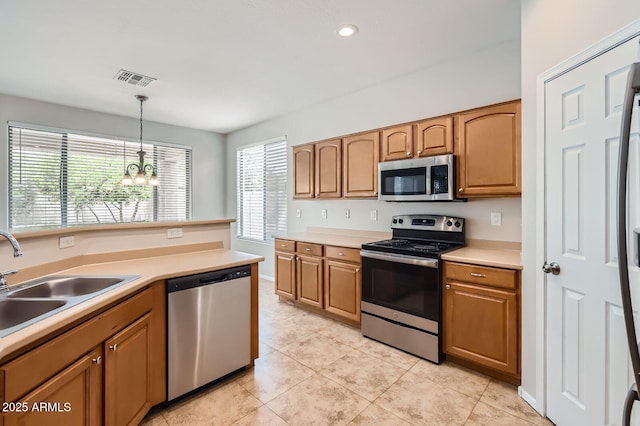 8766 W Hayward Ave, Glendale, AZ 85305 - kitchen featuring appliances with stainless steel finishes, a chandelier, a sink, decorative light fixtures, and light countertops