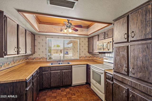 6015 W Acoma Dr, Glendale, AZ 85306 - kitchen with white appliances, wallpapered walls, a tray ceiling, dark brown cabinets, and a ceiling fan