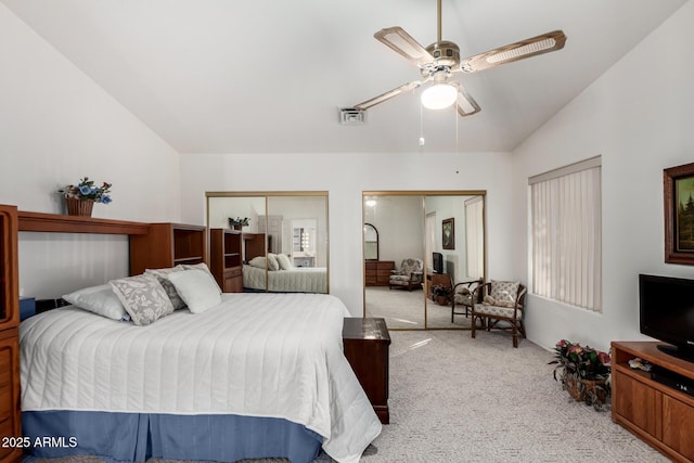 carpeted bedroom with lofted ceiling, ceiling fan, and multiple closets