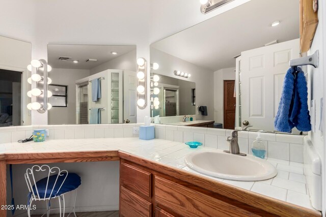 bathroom featuring vaulted ceiling and vanity