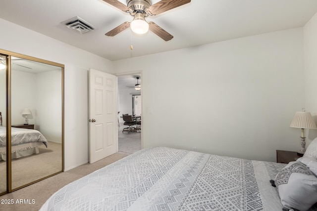 carpeted bedroom featuring ceiling fan and a closet