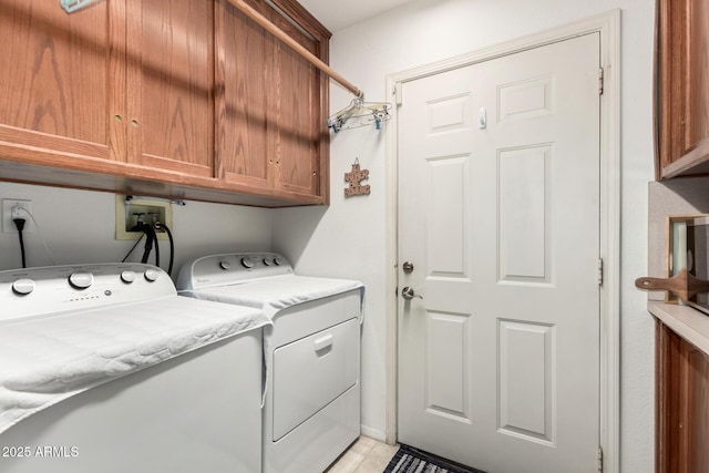 washroom featuring washing machine and clothes dryer and cabinets