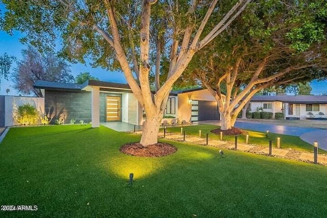 view of front of home with a front yard and a garage