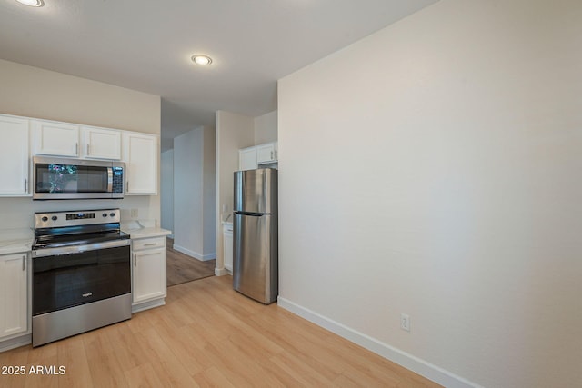 125 N 22nd Pl Unit 5, Mesa, AZ 85213 - kitchen with appliances with stainless steel finishes, light wood-style flooring, white cabinetry, and light countertops