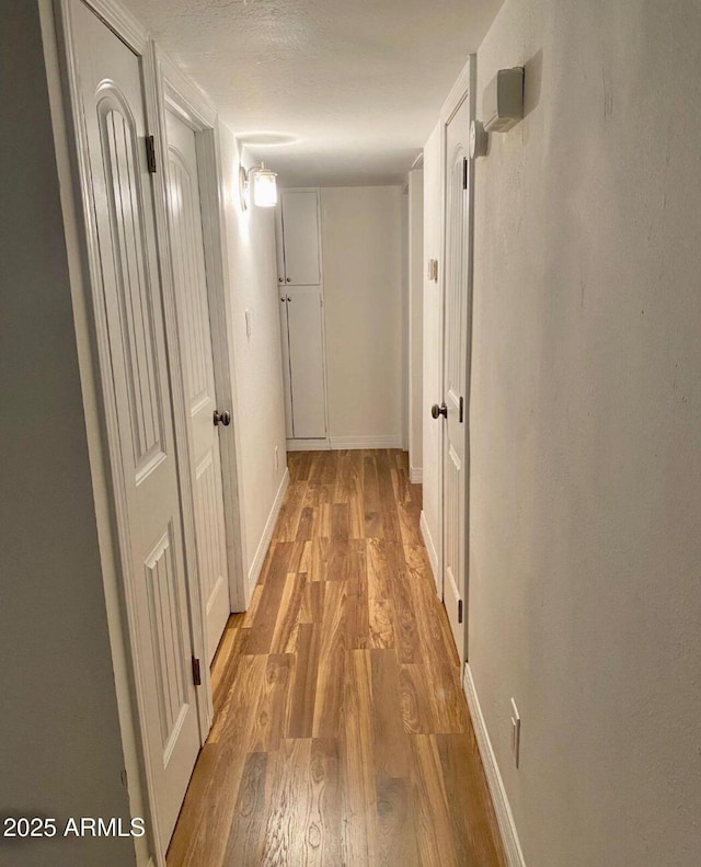 hallway with light hardwood / wood-style floors