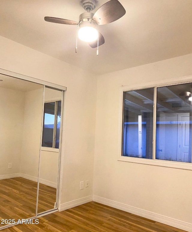 empty room with ceiling fan and dark hardwood / wood-style flooring