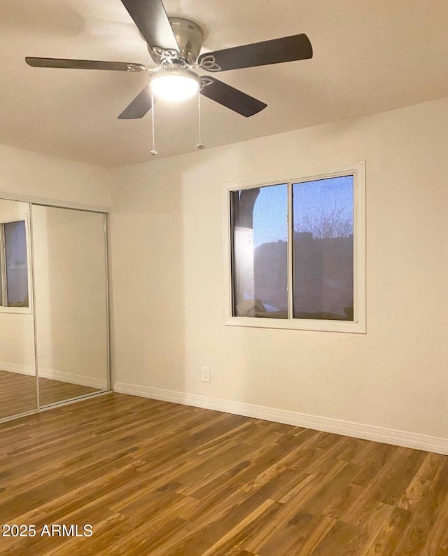 unfurnished bedroom featuring a closet, hardwood / wood-style flooring, and ceiling fan