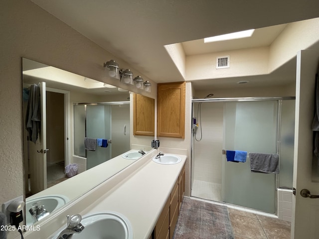 bathroom featuring a shower with door and vanity