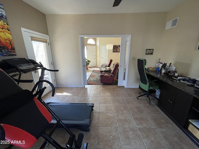 exercise area with light tile patterned floors and ceiling fan