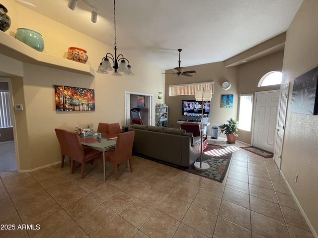 tiled dining room featuring rail lighting and ceiling fan with notable chandelier