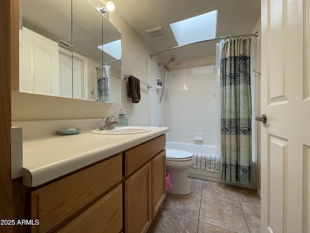 full bathroom featuring vanity, a textured ceiling, tile patterned floors, toilet, and shower / bath combo with shower curtain