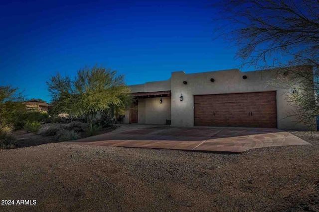 pueblo revival-style home with a garage