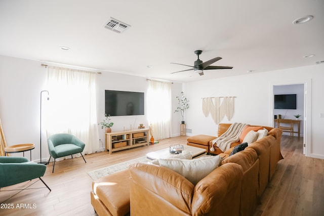 living room featuring ceiling fan, visible vents, and wood finished floors