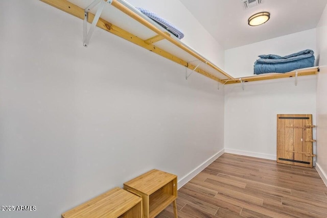 spacious closet featuring visible vents and wood finished floors