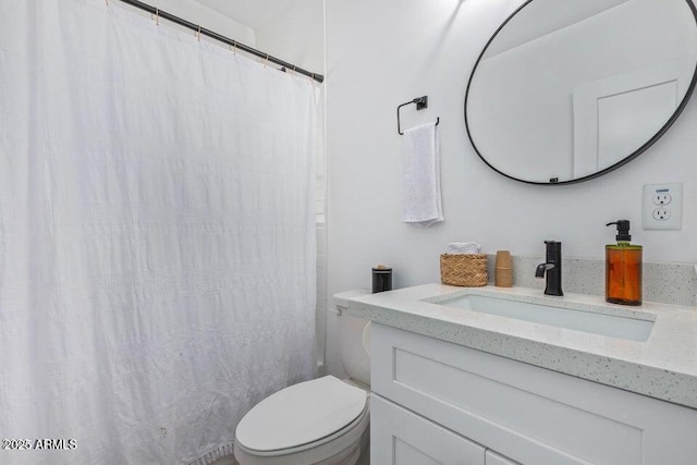 bathroom featuring toilet, a shower with shower curtain, and vanity