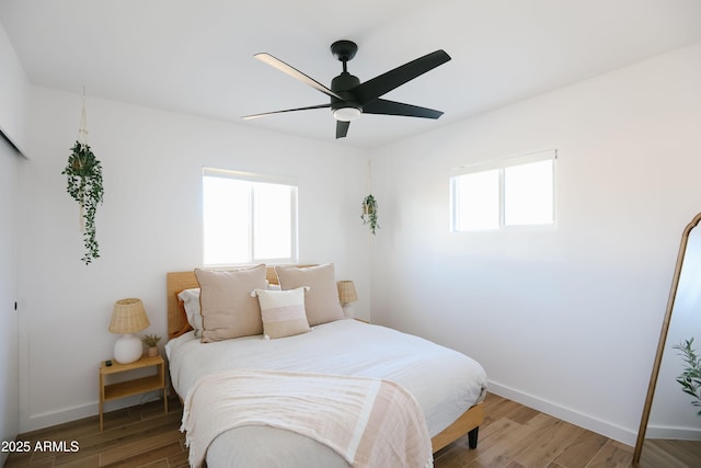 bedroom featuring baseboards, ceiling fan, and light wood-type flooring
