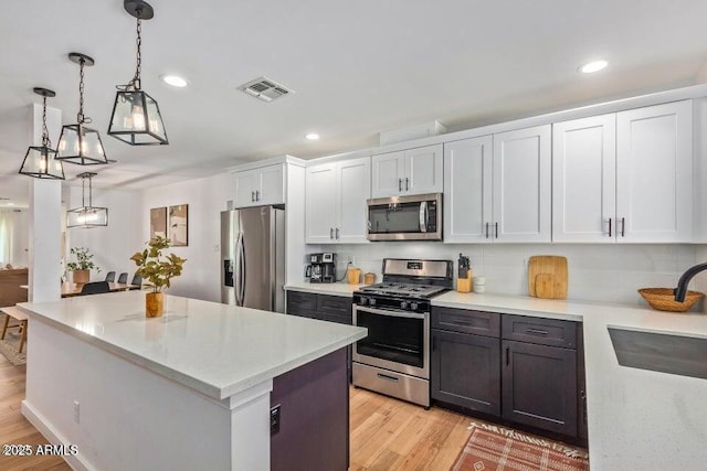 kitchen featuring light countertops, visible vents, stainless steel appliances, a sink, and light wood-style floors