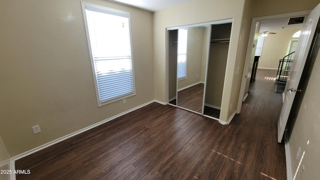 5628 S 21st Pl, Phoenix, AZ 85040 - unfurnished bedroom featuring dark wood-style flooring, a closet, and baseboards