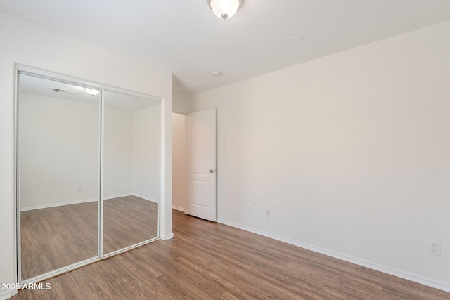 5628 S 21st Pl, Phoenix, AZ 85040 - unfurnished bedroom with wood finished floors, baseboards, and a closet