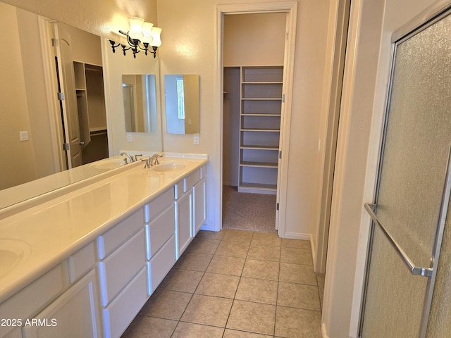 bathroom with vanity, a shower with door, a chandelier, and tile patterned flooring