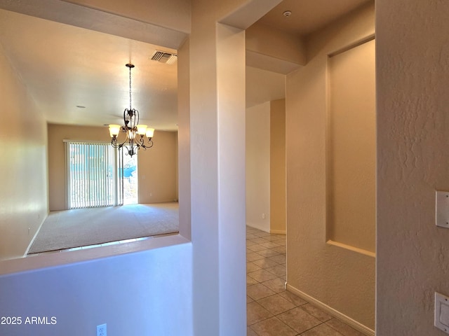 corridor with a chandelier and tile patterned flooring